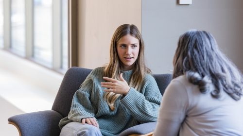 The young adult female talks to the counselor about her ADHD.